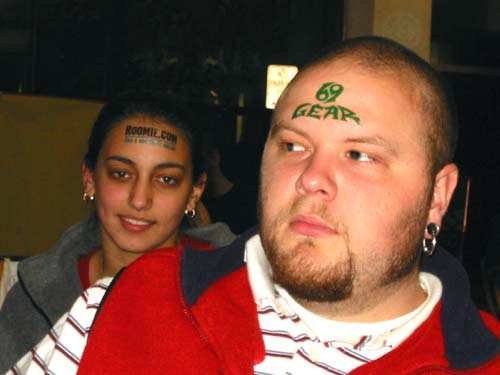 Two Headvertise participants wearing Roommates.com and 69 Gear forehead advertisements.
